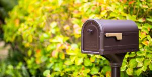 Decorative bronze mailbox in greenery