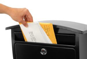 Open black wall mount mailbox with mail inside