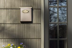 Decorative bronze wall mounted mailbox on a house