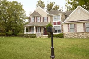 Black mailbox with a gray flag raised on a lawn