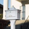 Zoomed in image of white post mount mailbox with decorative background