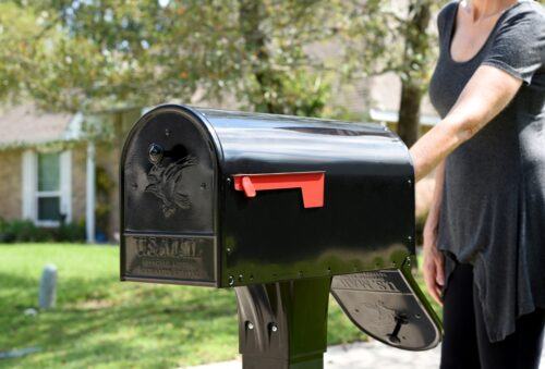 Decorative Background of Post Mount Mailbox with an Individual Reaching to Grab Mail