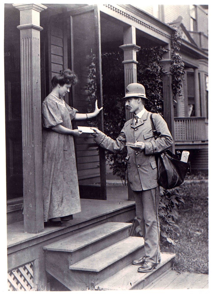 Old photo of post man handing mail to women