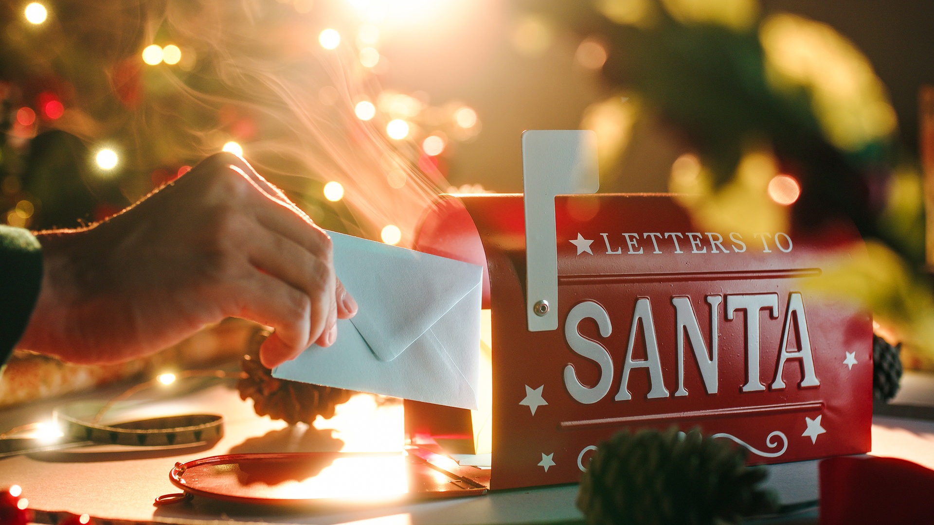 Man putting a letter for Santa Claus into the mail box