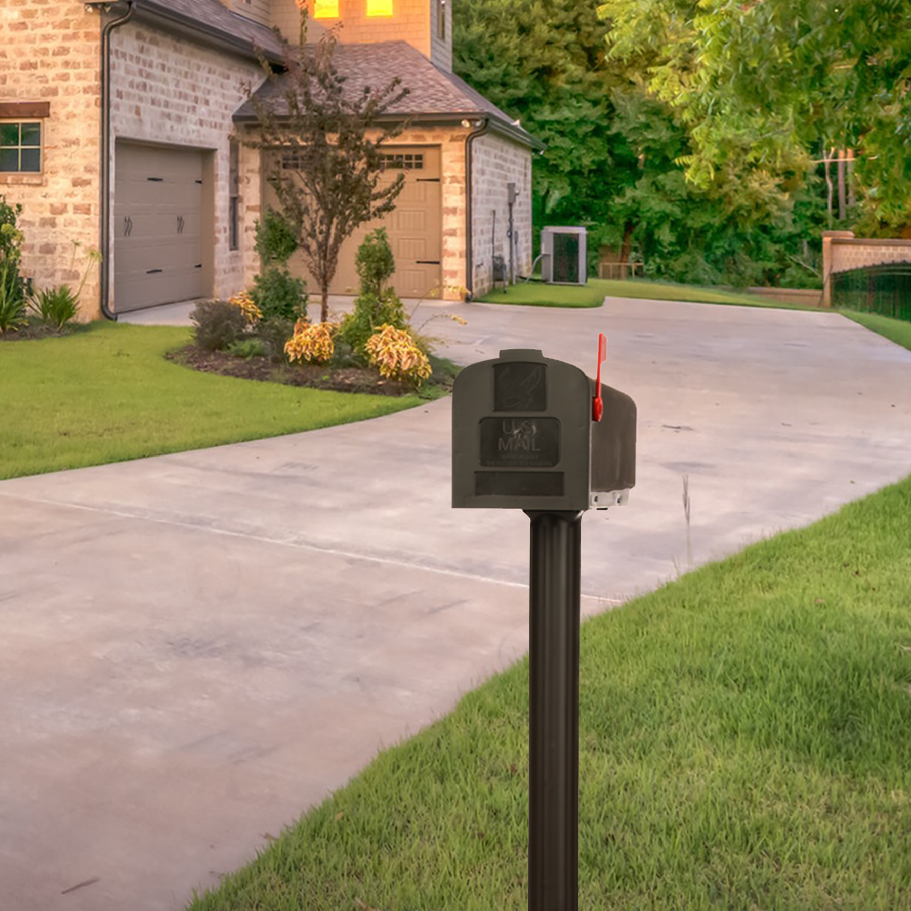 Mailbox on a black post in the foreground of a suburban street, with a curved driveway and houses in the background.