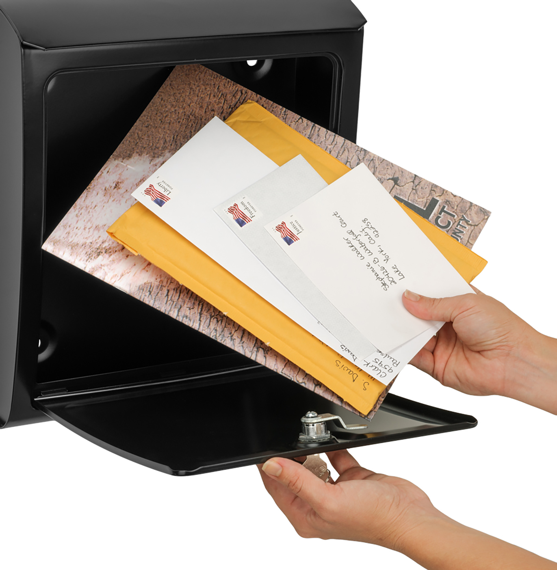 Person depositing envelopes into a black safe's mail slot.