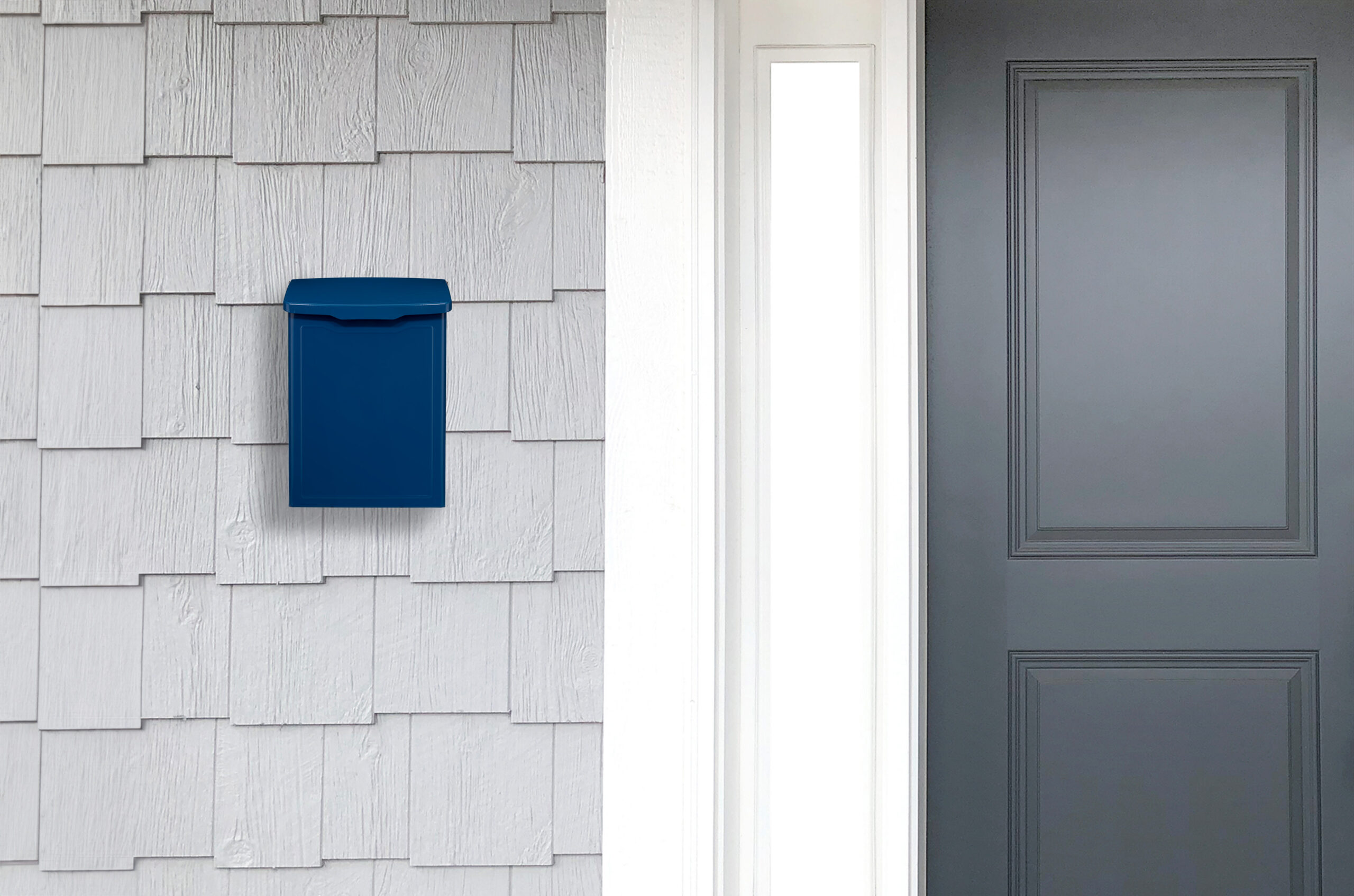 Blue wall-mounted mailbox on light gray siding next to a white door frame and dark entry door nearby.