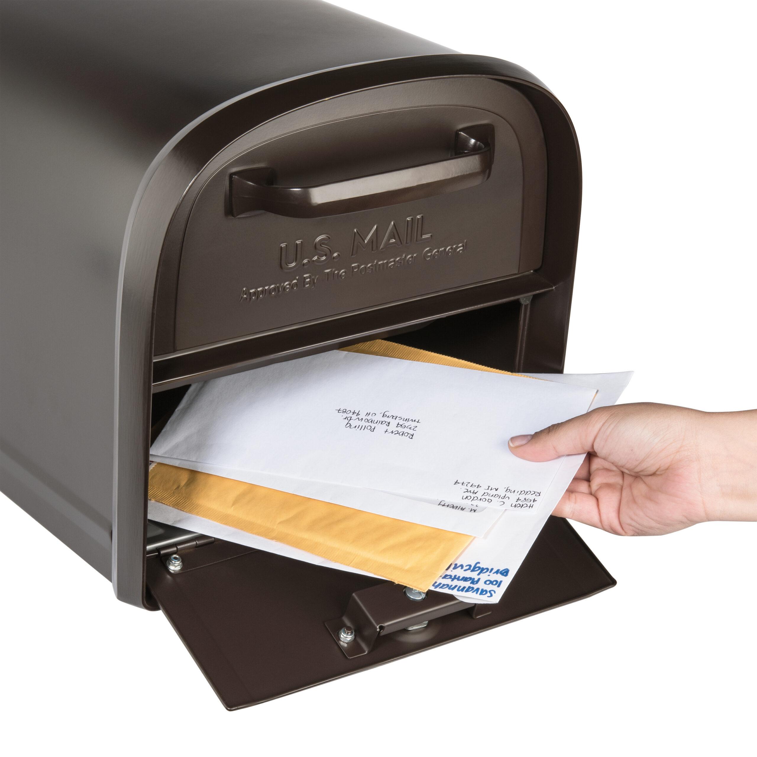 Hand inserting white envelopes into a brown U.S. Mail mailbox with the slot open.