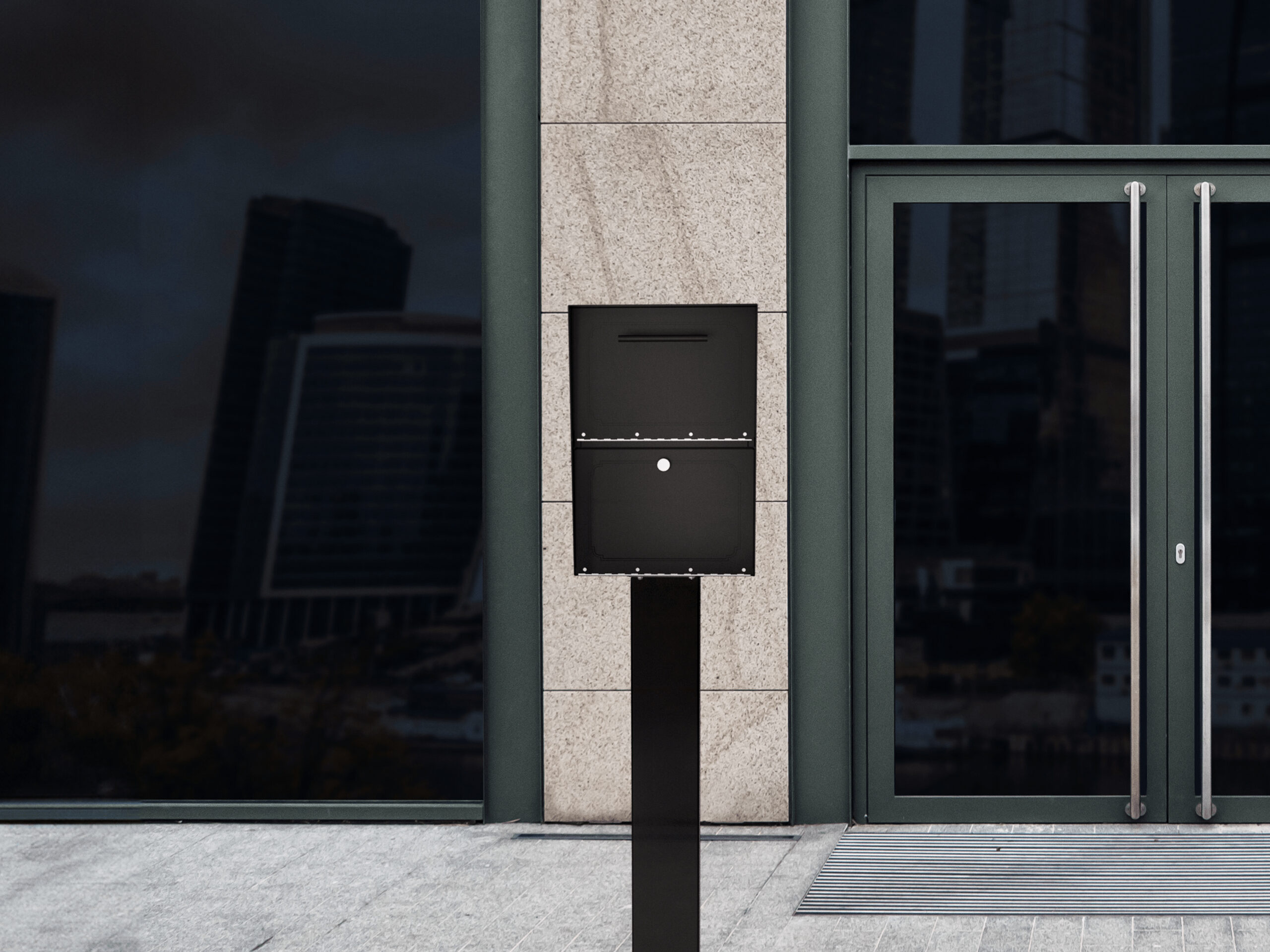 Modern building entrance with a black pedestal mailbox/slot box in front of a granite wall and glass doors.