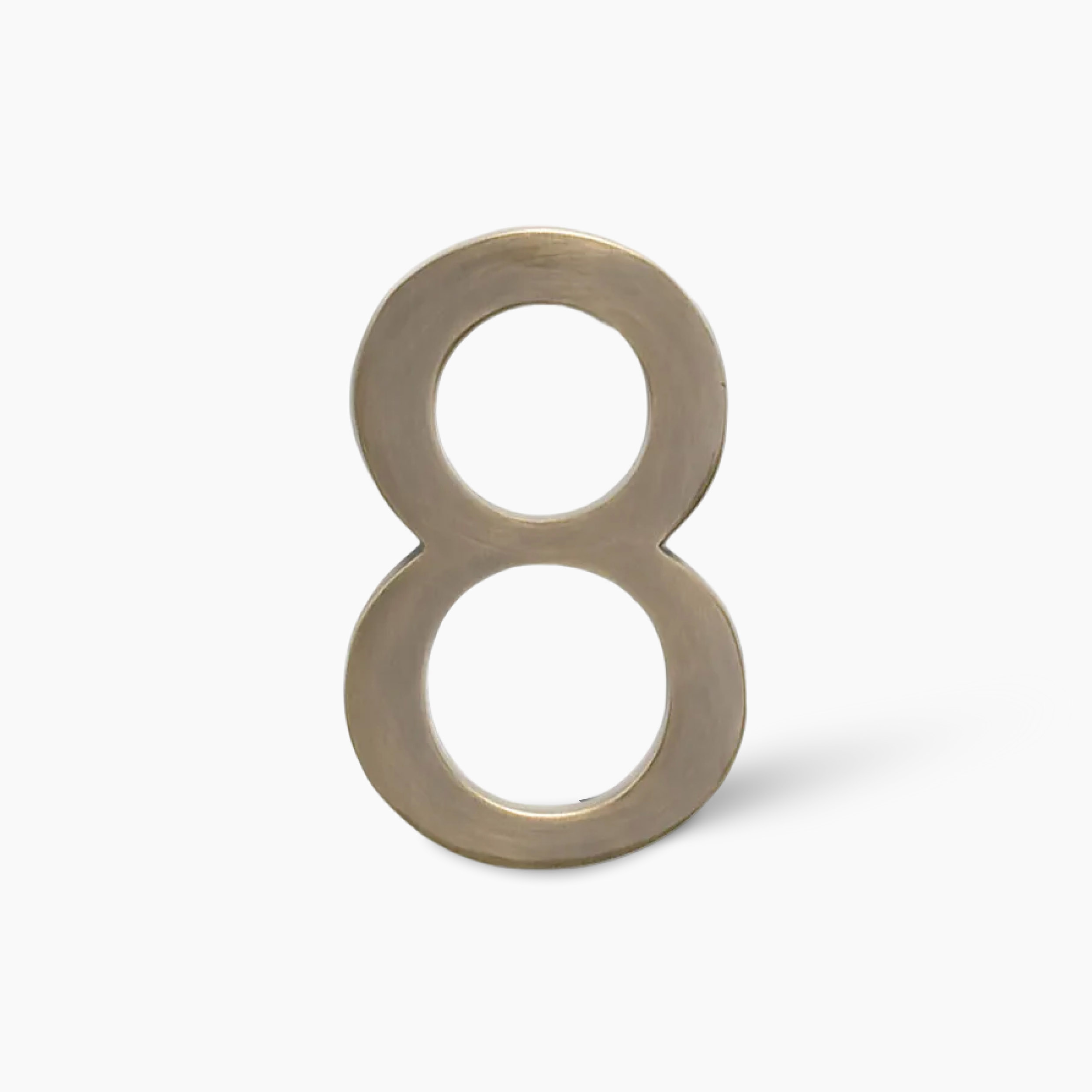 Metal numeral eight standing upright on a white background with a soft shadow