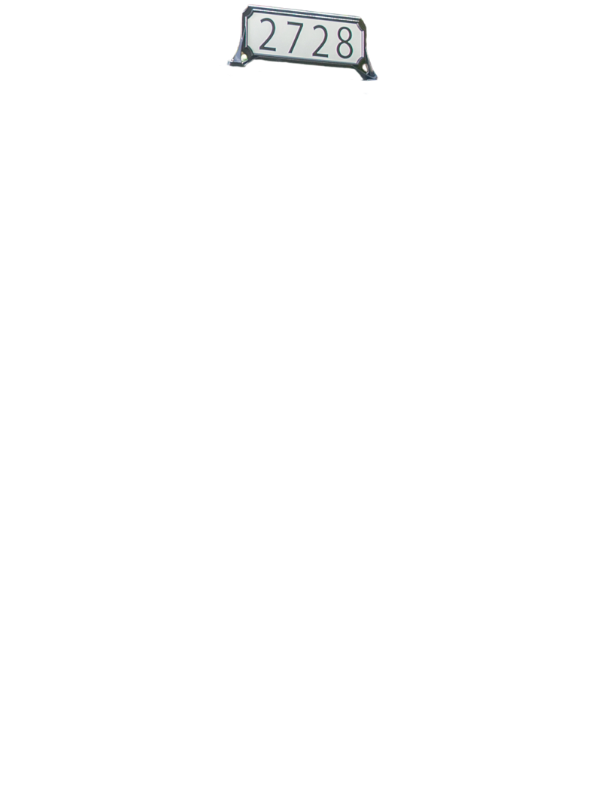 Metal framed number sign reading 2728 near the top edge of a black background.